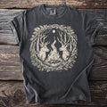 Dark grey t-shirt with a graphic of two deer, a campfire, and a moon within a wreath.