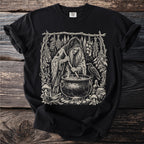 Black t-shirt featuring an illustration of a witch stirring a cauldron with a raven nearby.