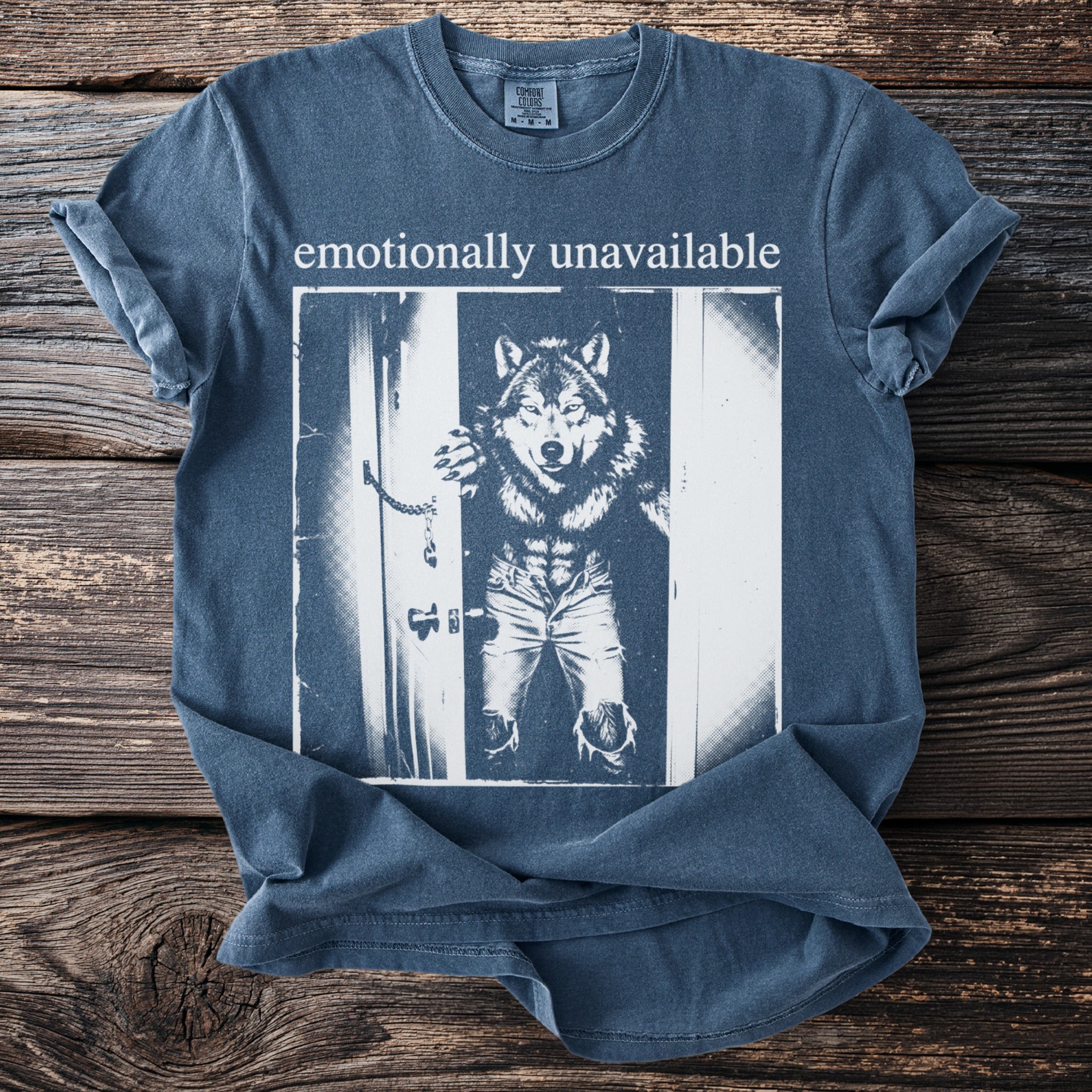 T-shirt with "emotionally unavailable" text and a wolf-man graphic in ripped jeans.