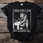 Black t-shirt with a graphic of a werewolf brushing its teeth and text "i miss who i was five minutes ago".