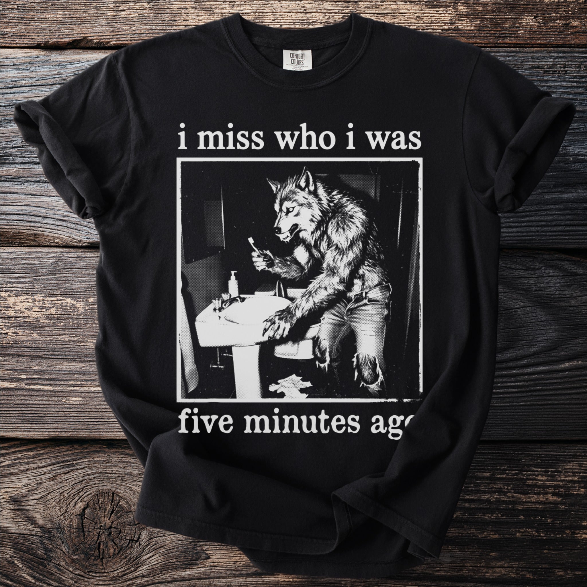 Black t-shirt with a graphic of a werewolf brushing its teeth and text "i miss who i was five minutes ago".