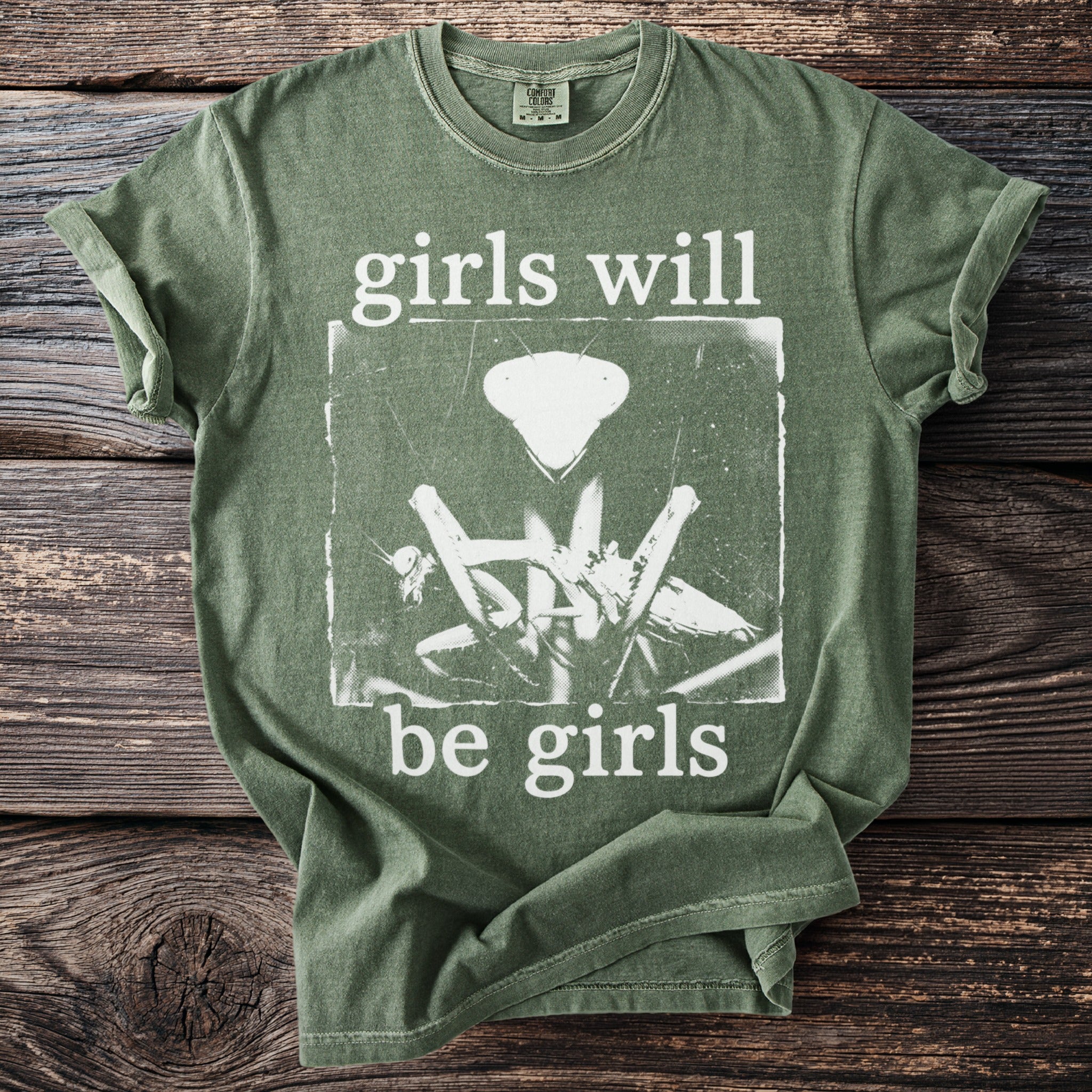 Green t-shirt with "girls will be girls" text and praying mantis graphic.