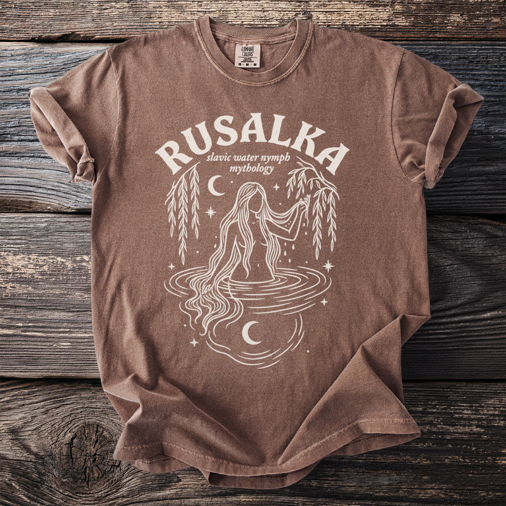 Brown t-shirt with white graphic of a Rusalka and "Slavic water nymph mythology".