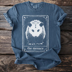 Blue t-shirt with opossum graphic and text "the menace" in a tarot card design.