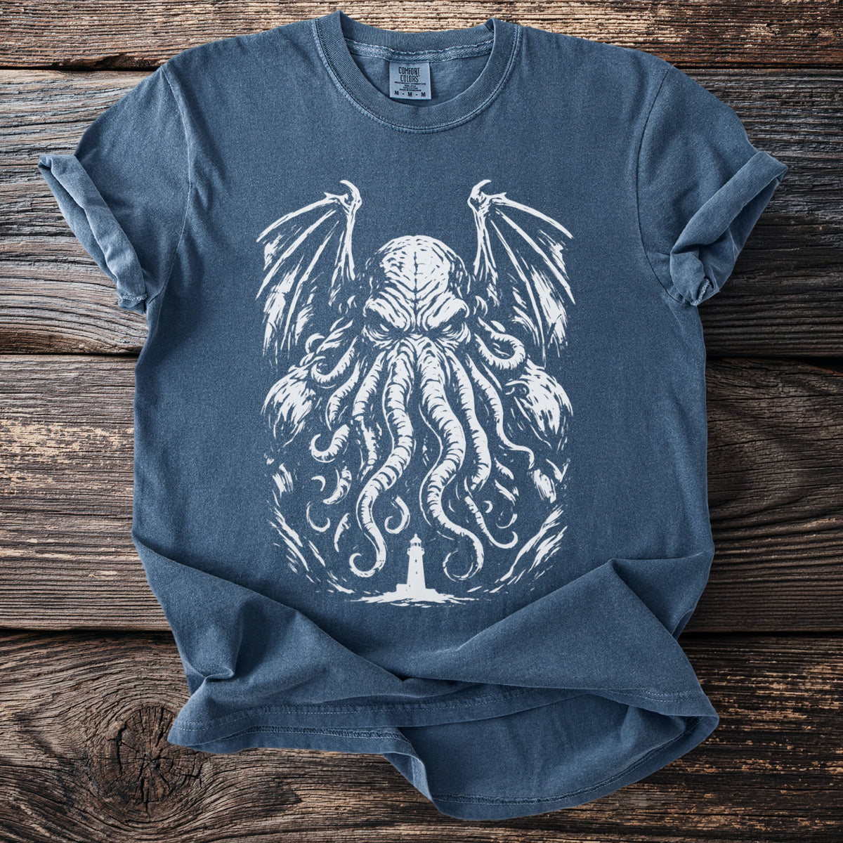 Blue t-shirt with white tentacled creature and lighthouse graphic.