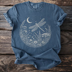 Blue t-shirt with a circular print of a dragonfly among flowers, moon, and stars.