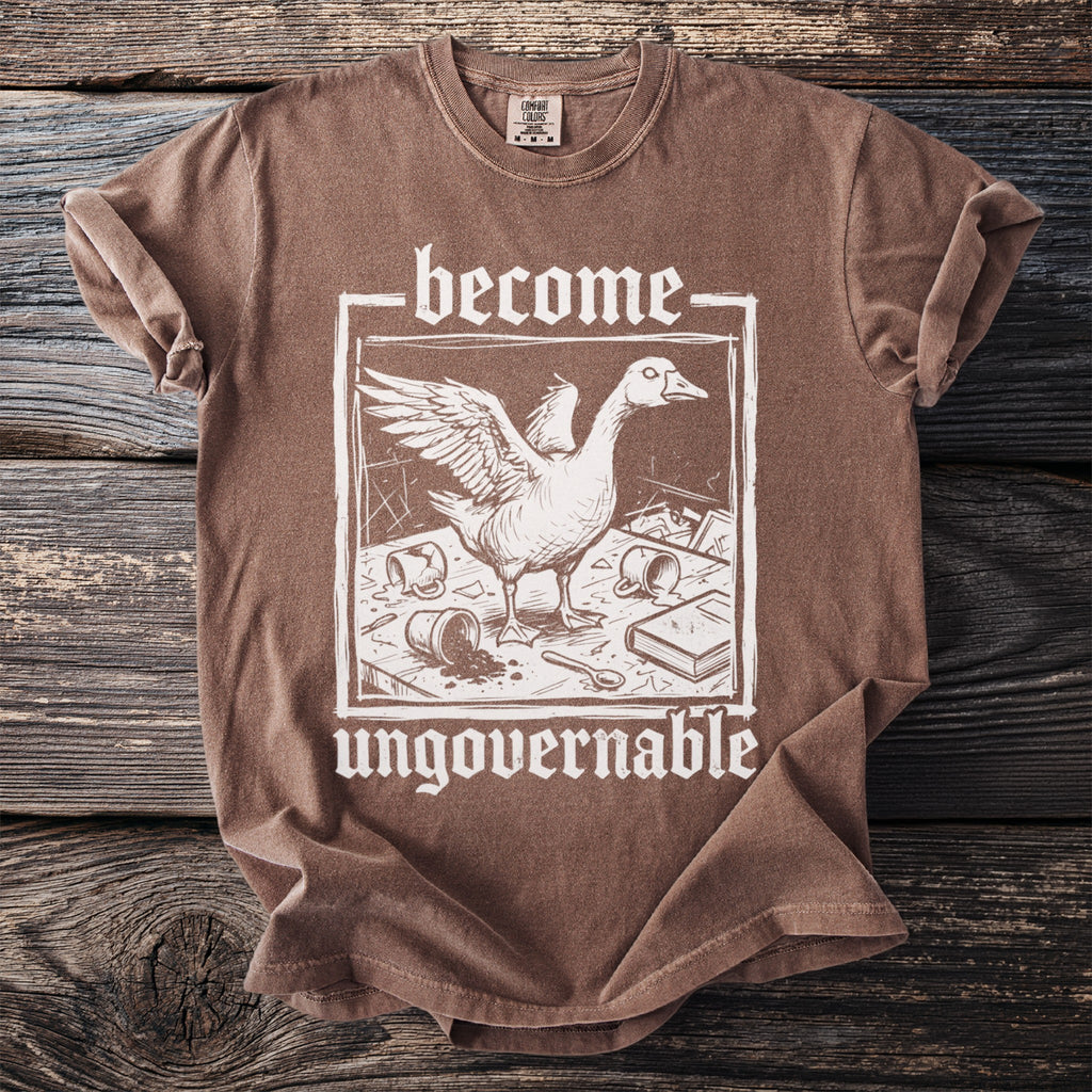 Brown t-shirt with white text "become ungovernable" and goose illustration.