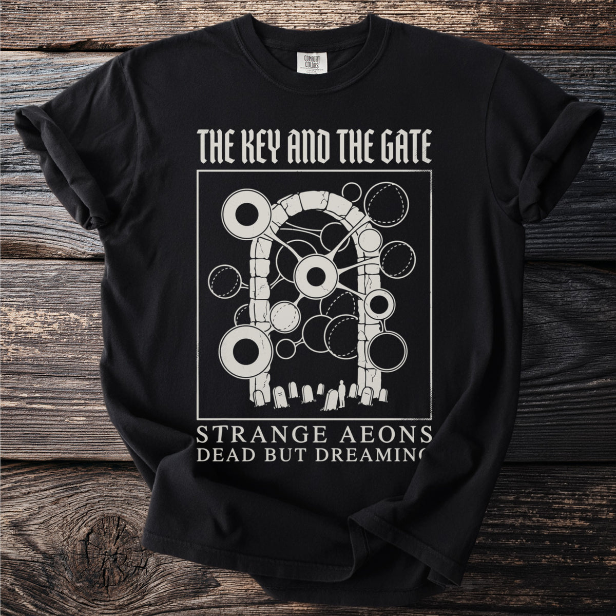 Black t-shirt with "The Key and the Gate" graphic and text "Strange Aeons Dead But Dreaming".