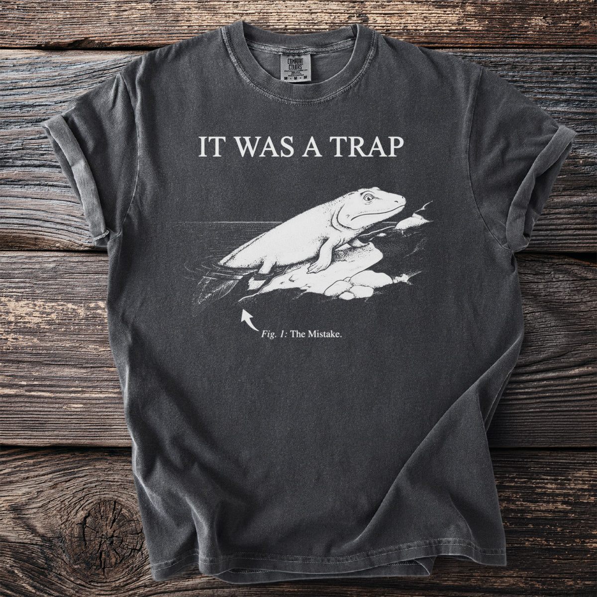 Charcoal t-shirt with IT WAS A TRAP and an engraved Tiktaalik, a lobe-finned fish, hauling itself onto rock, captioned Fig. 1: The Mistake.
