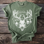 Green t-shirt with white graphic of deer skull, holly, ornaments, and skulls.