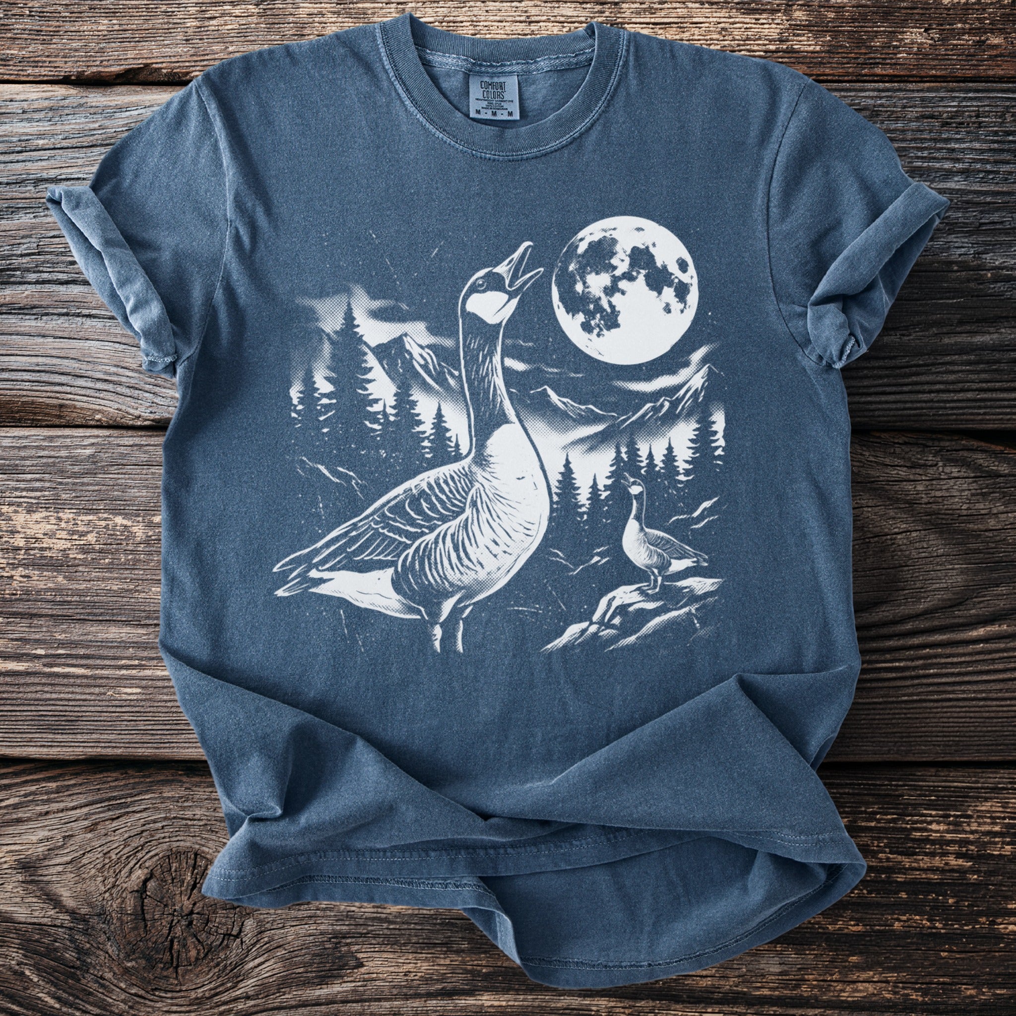 T-shirt with geese, mountains, trees, and a full moon graphic.