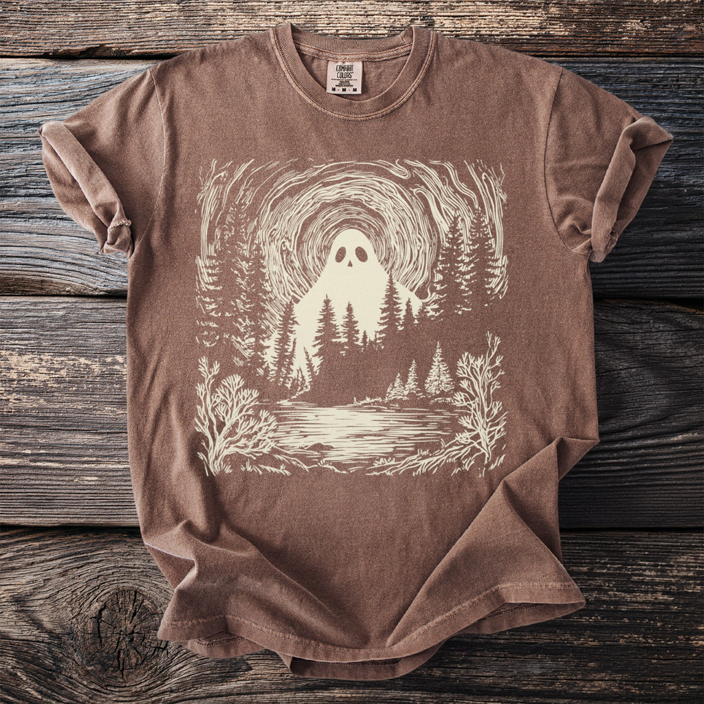 Brown t-shirt with a cream graphic of a ghost in a forest by a lake.
