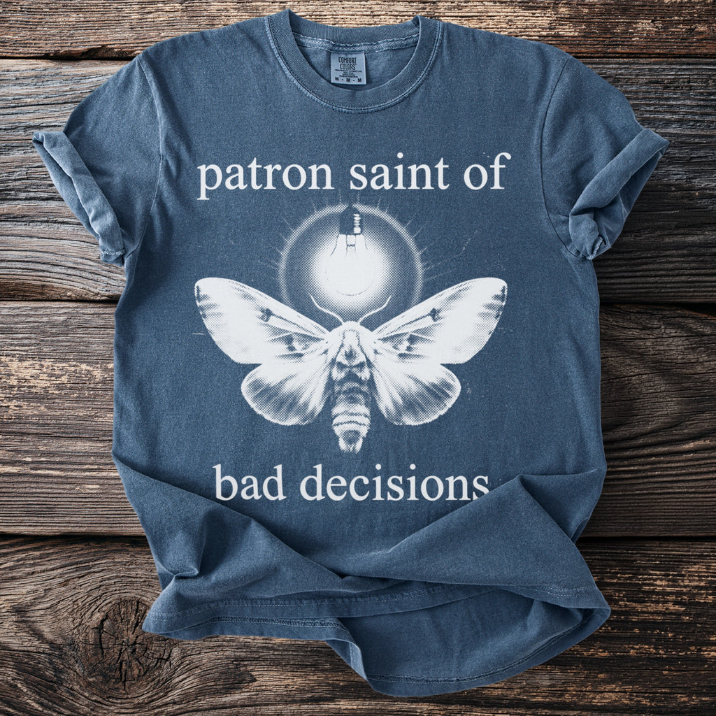Blue t-shirt with moth illustration and text "patron saint of bad decisions".
