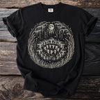 Black t-shirt with a vintage circle design of fairies dancing among mushrooms under a moonlit forest.