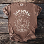 Brown t-shirt with "The Moon tarot card arcana lunar mystery" design.