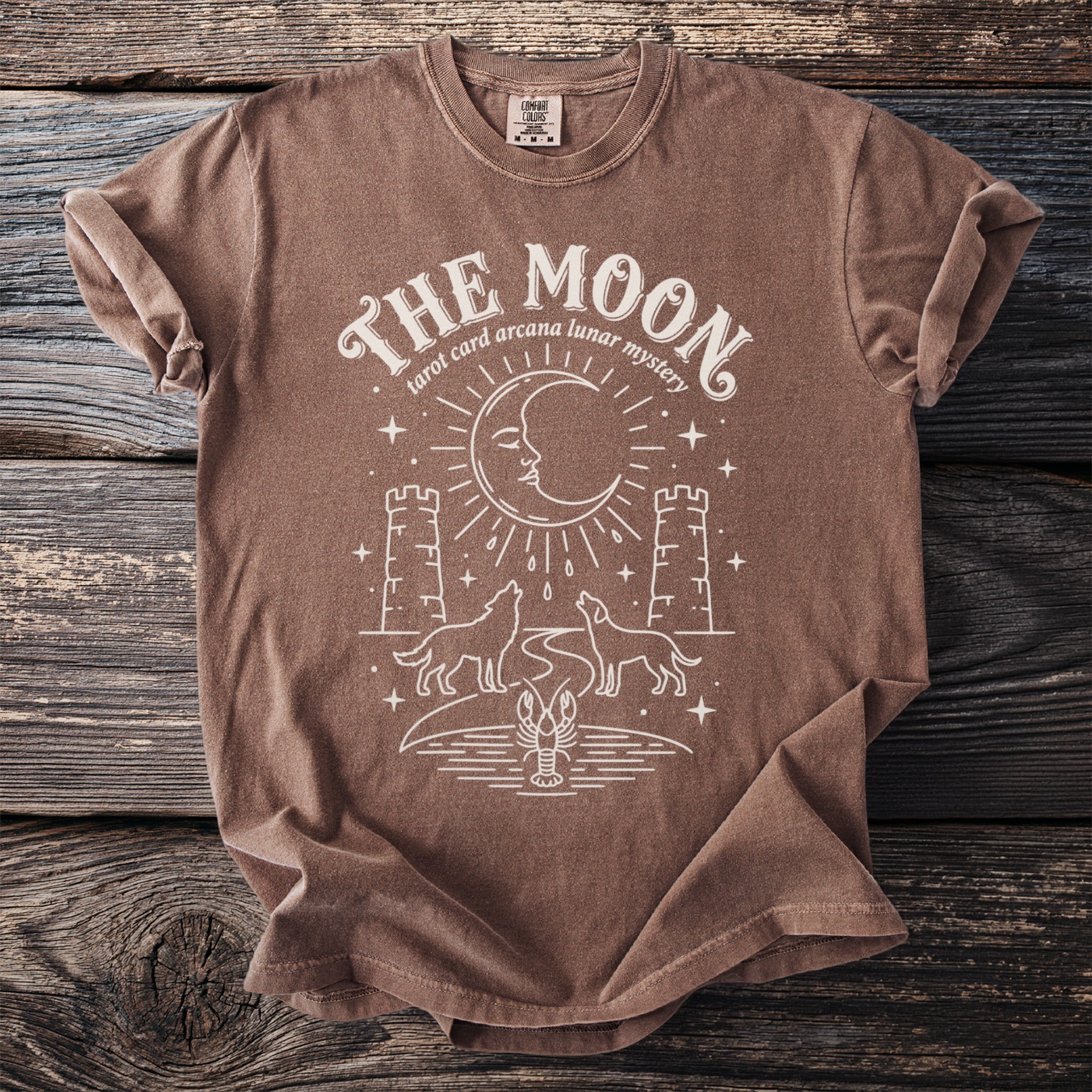 Brown t-shirt with "The Moon tarot card arcana lunar mystery" design.