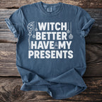 Blue t-shirt with white text "Witch Better Have My Presents" and witchy graphics.