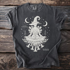 Dark grey t-shirt with a meditating figure, witch hat, flowers, moon, and stars.