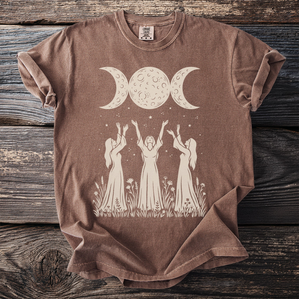 Brown t-shirt with triple moon goddess design and three women reaching up.