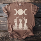 Brown t-shirt with triple moon goddess design and three women reaching up.
