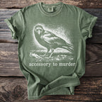Olive green t-shirt with a crow graphic and text "accessory to murder".
