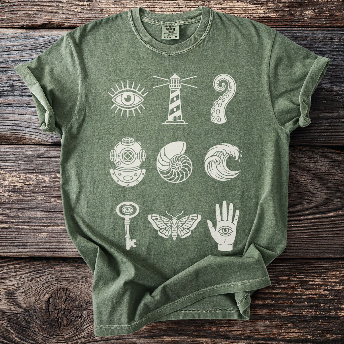 Green t-shirt with white graphic icons: eye, lighthouse, tentacle, helmet, shell, wave, key, moth, hand.