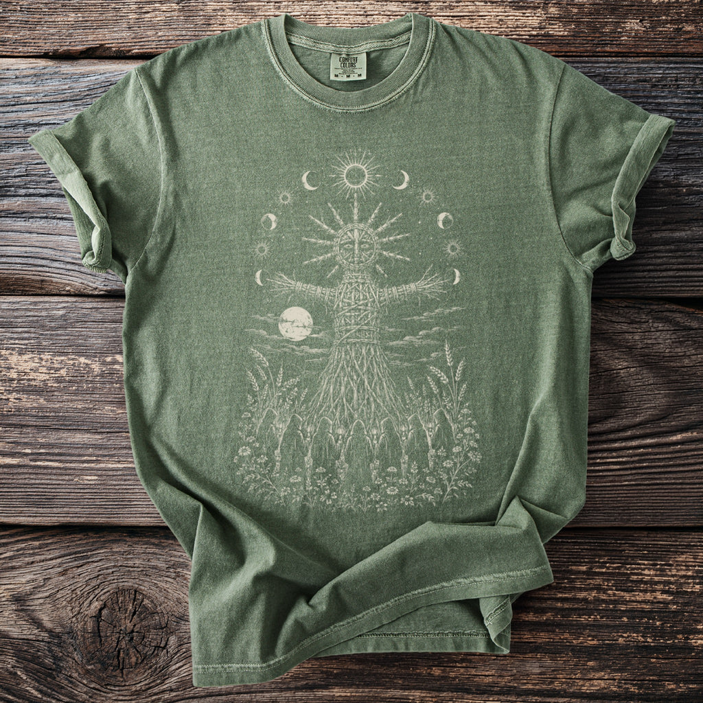 Green t-shirt with a woven figure, moon, and celestial bodies graphic.
