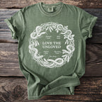 Green t-shirt with white circular snake diagram and text "LOVE THE UNLOVED".