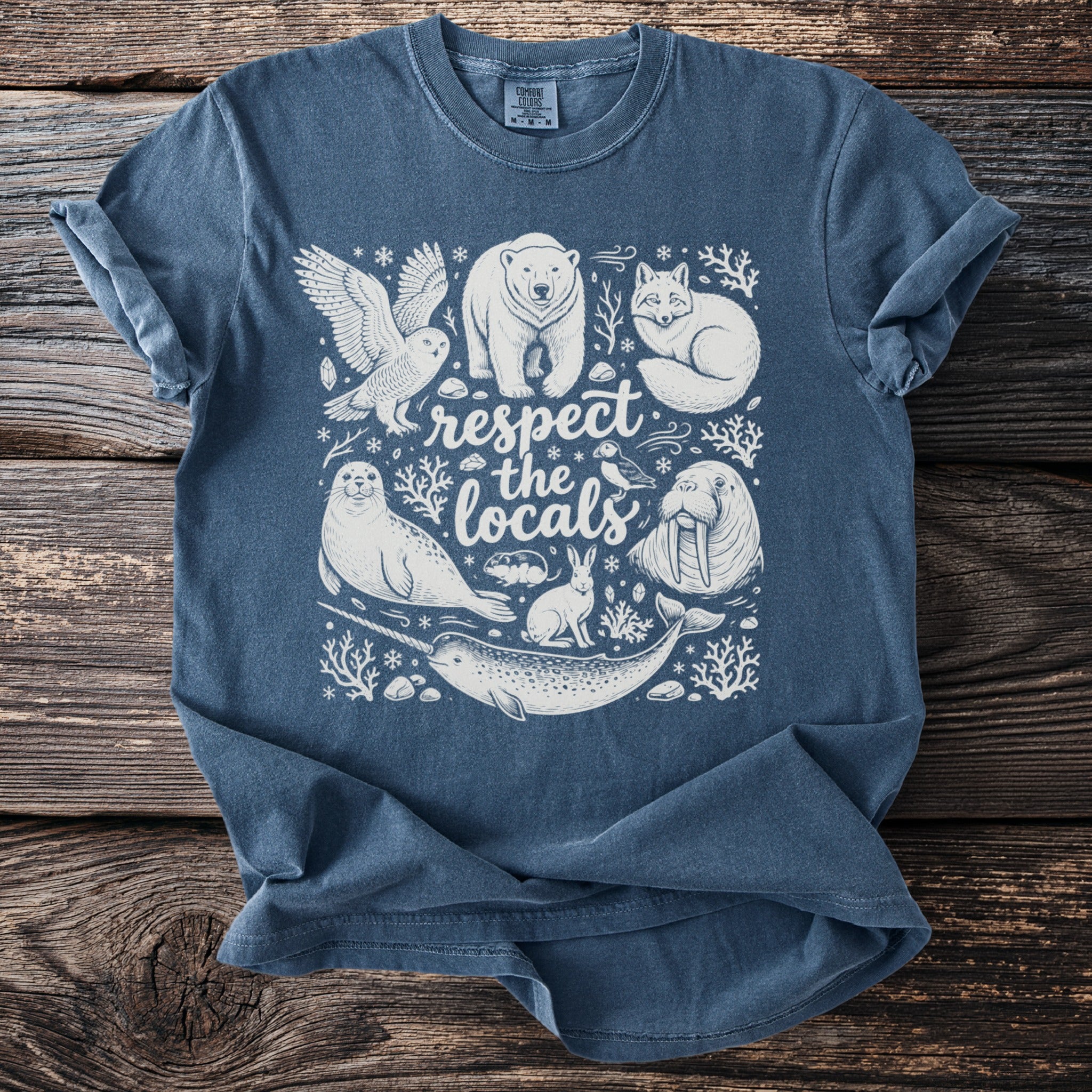 Arctic animals and text "respect the locals" screen printed on a blue t-shirt.