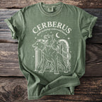 Green t-shirt with white graphic of three-headed Cerberus and text "CERBERUS Greek mythology underworld hound".