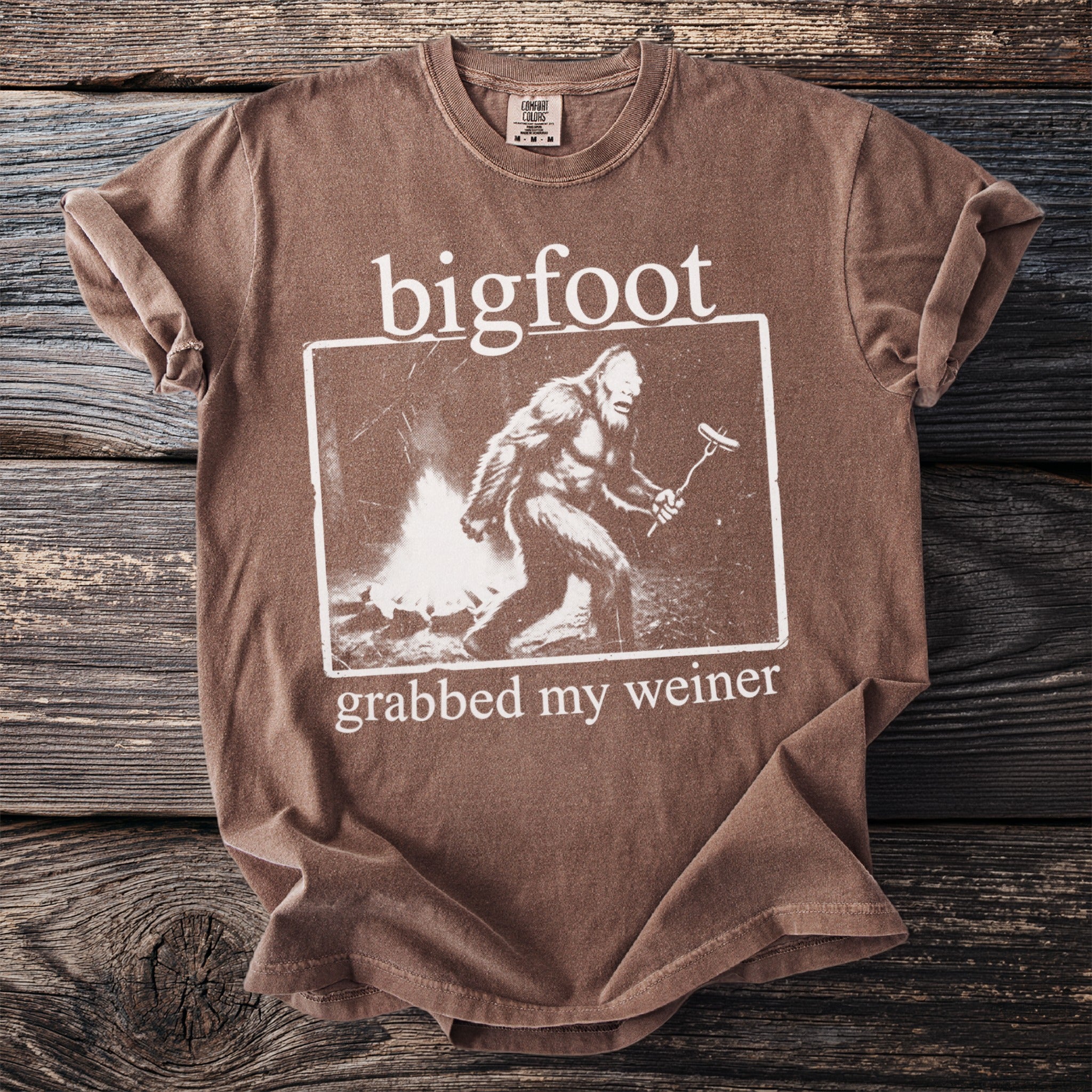 Brown Comfort Colors t-shirt with "bigfoot grabbed my weiner" graphic.