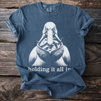 Blue t-shirt with white graphic of pelican holding fish and text "holding it all in."