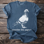Blue t-shirt with white print of a pigeon and text "consider the pigeon".