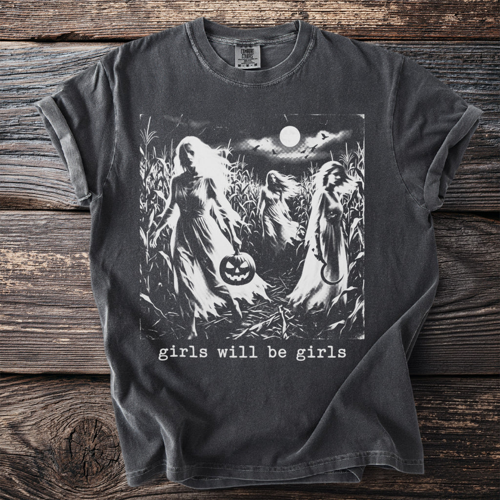 Dark t-shirt with graphic of ghostly figures in a cornfield holding a pumpkin.
