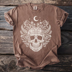 Brown t-shirt with white skull, floral, and moth design and moon.