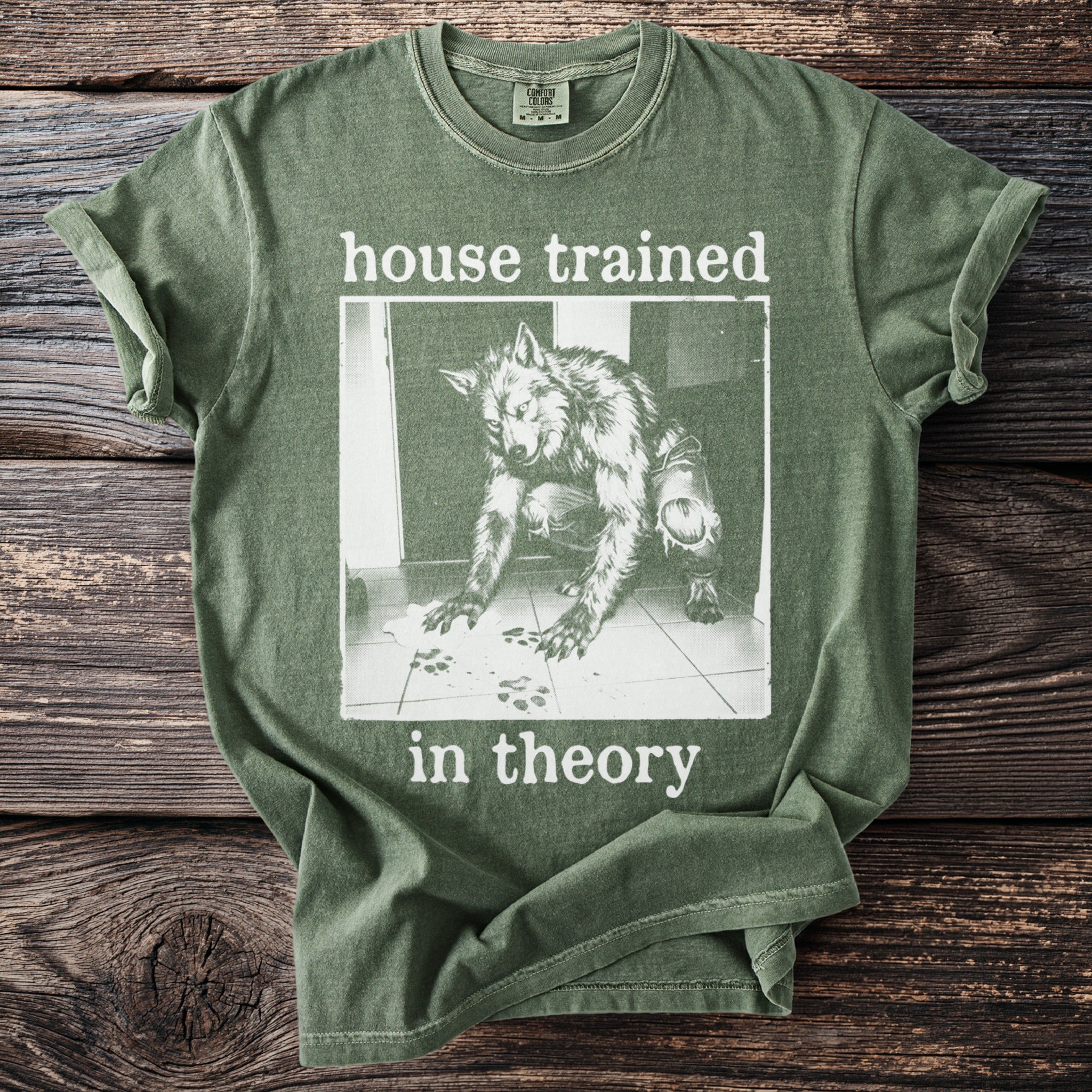 Green t-shirt with a werewolf illustration and the text "house trained in theory".