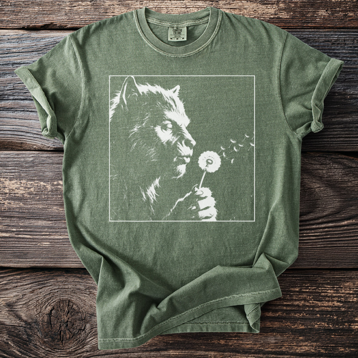 Green t-shirt with werewolf blowing dandelion seeds graphic.