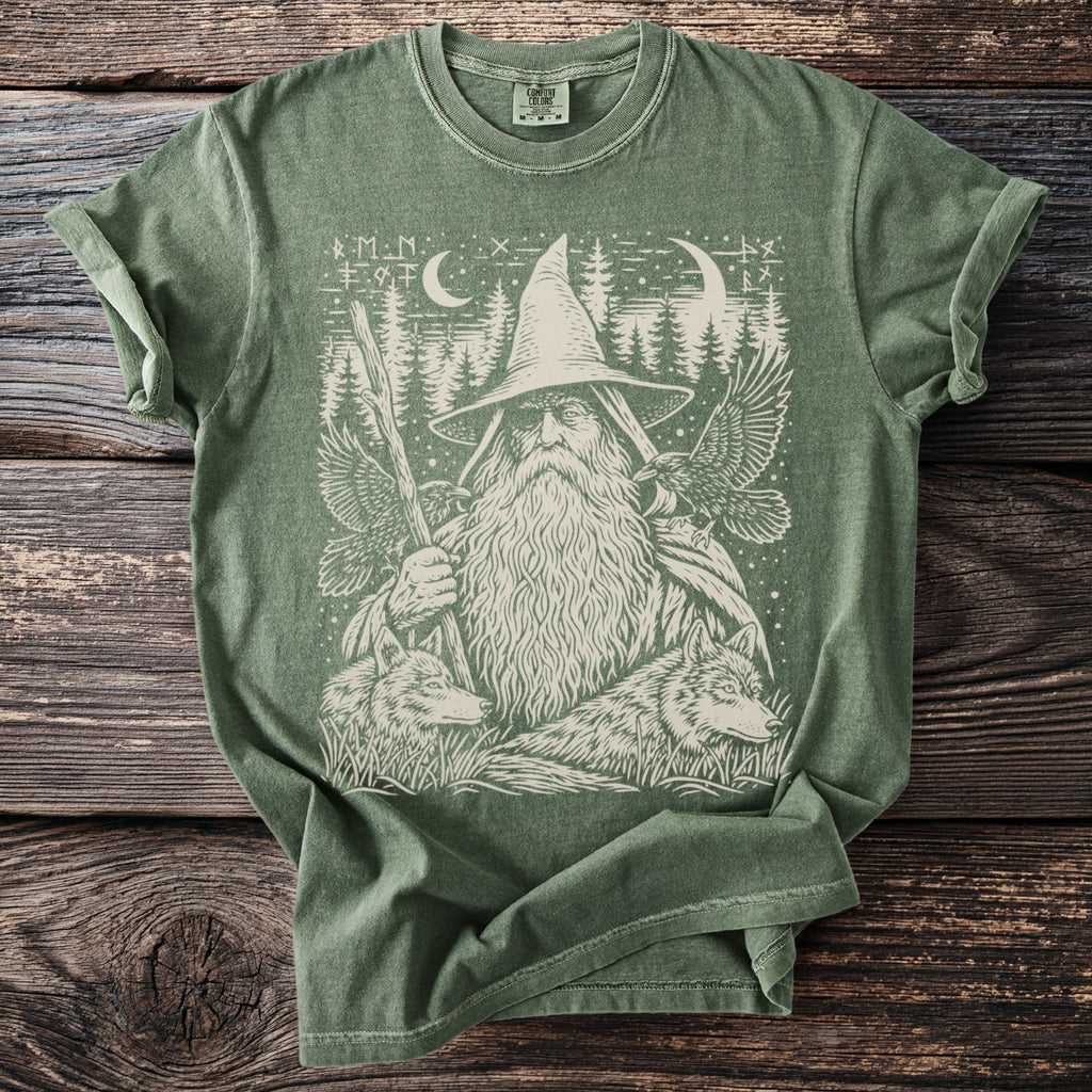 Green t-shirt with a graphic print of a wizard, wolves, and eagles in a forest.