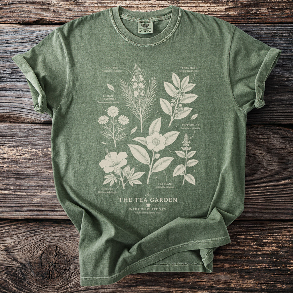 Green t-shirt with "The Tea Garden" graphic of botanical tea ingredients.