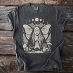 Dark grey t-shirt with a mystical illustration of a woman, moth wings, moons, and mushrooms.