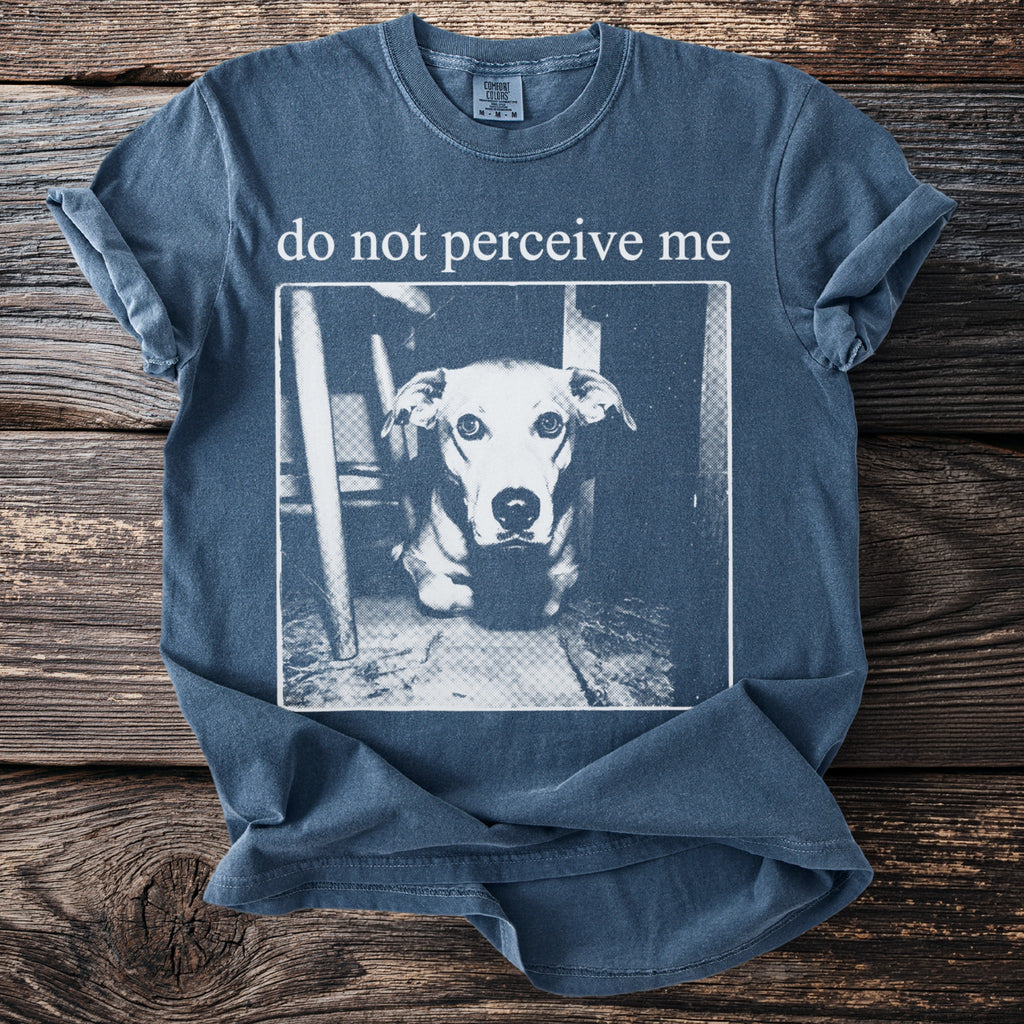 Blue t-shirt with "do not perceive me" text above a dog portrait.