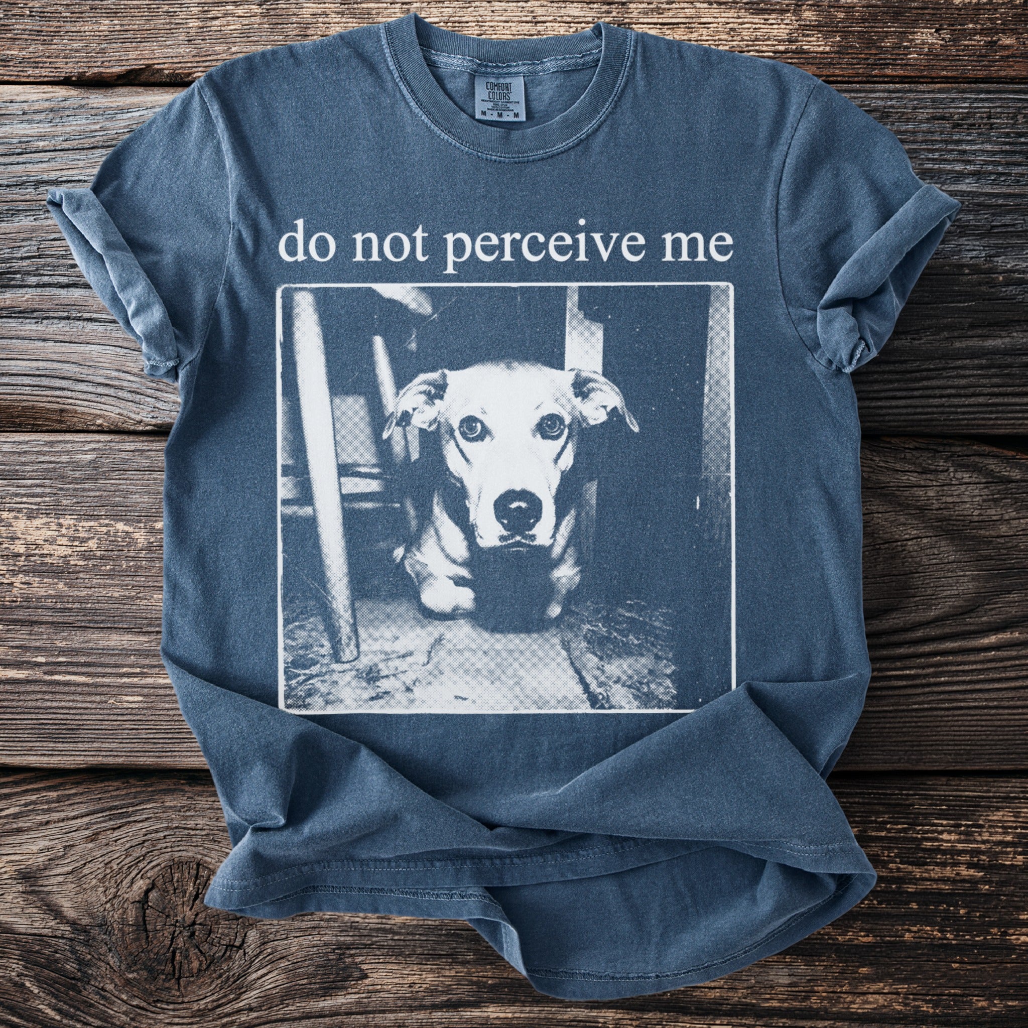 Blue t-shirt with "do not perceive me" text above a dog portrait.