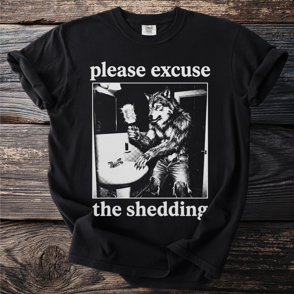 Black t-shirt with werewolf in bathroom and text "please excuse the shedding".