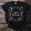 Black t-shirt with "respect the locals" text surrounded by hummingbirds and flowers.