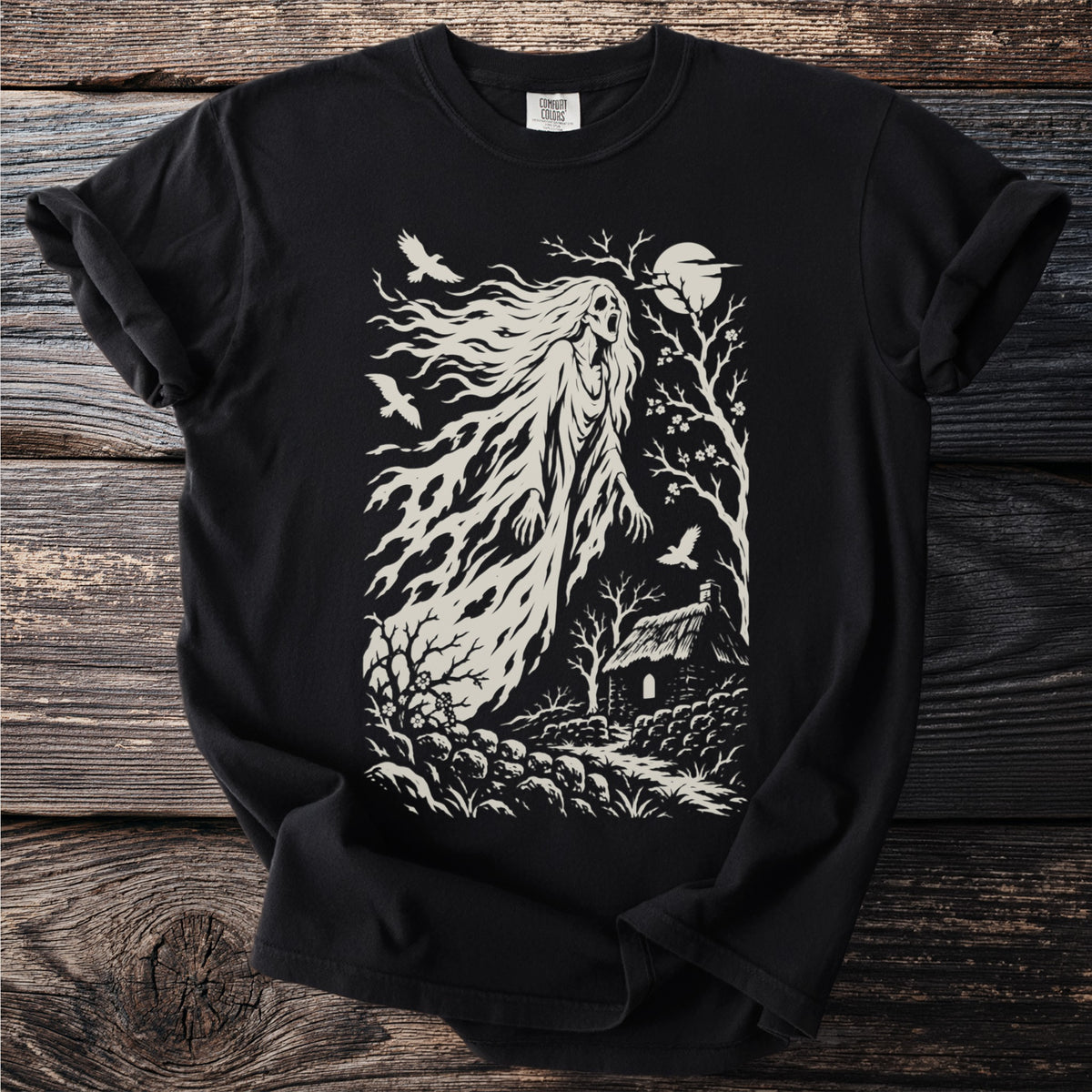 Black t-shirt with a distressed print of a ghostly figure near a thatched cottage.