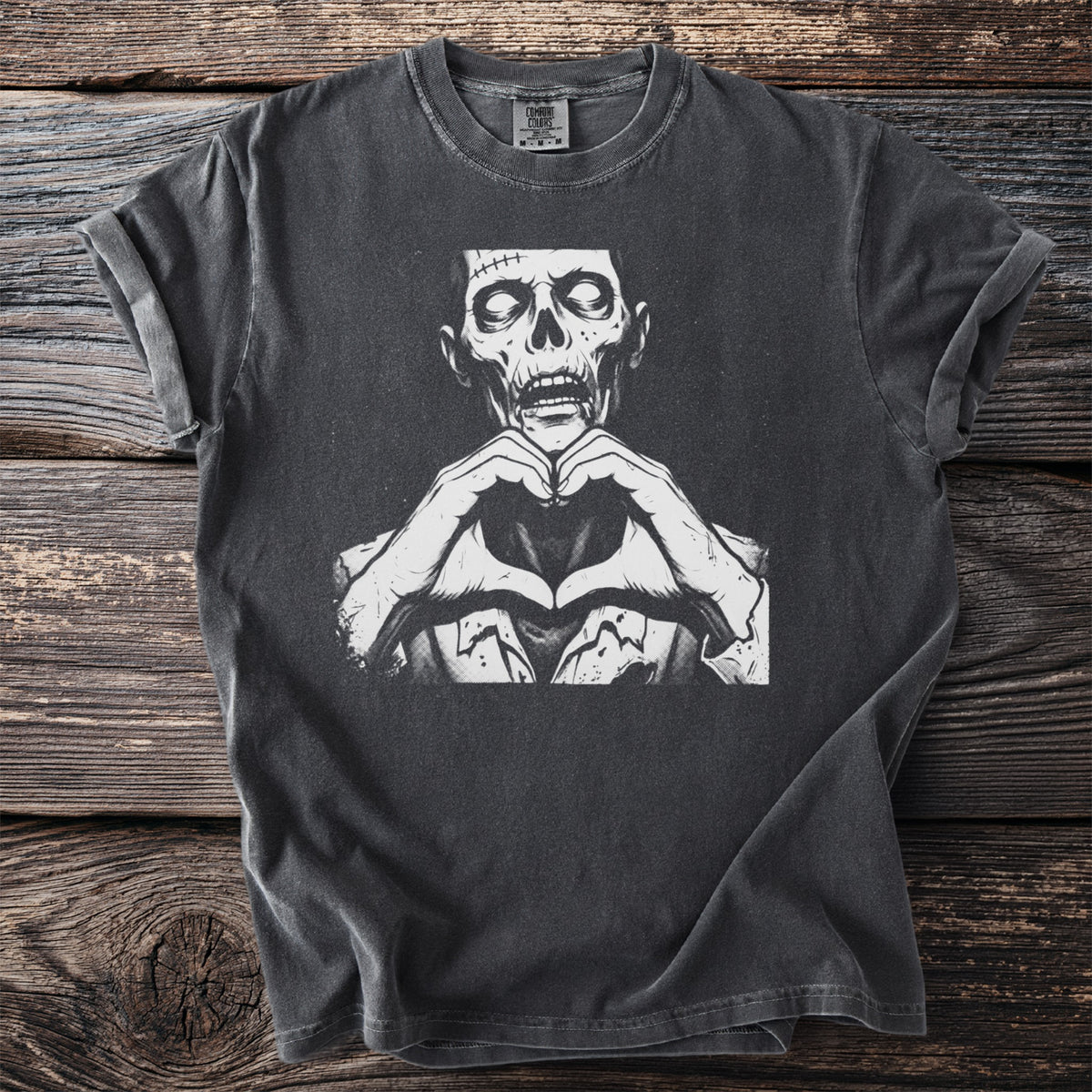 Dark grey t-shirt with a black and white graphic of a zombie making a heart shape with its hands.