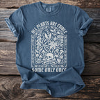 Blue t-shirt with white text and skull with bones illustration.