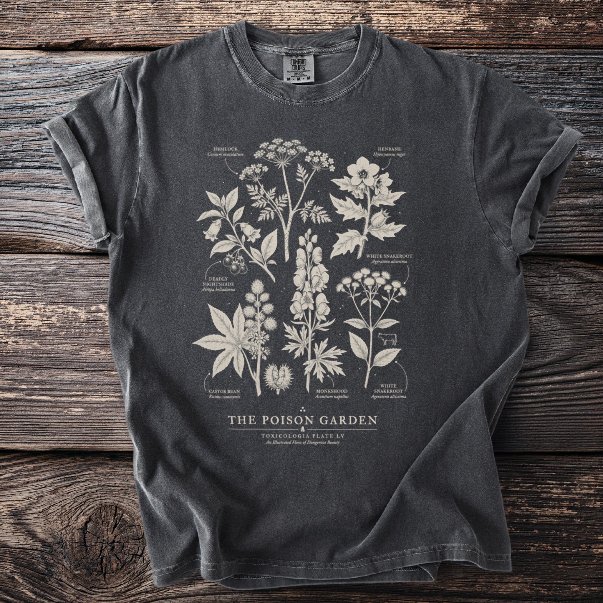 Dark grey t-shirt featuring white scientific illustrations of poisonous plants and Latin names.