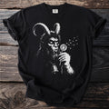 Black t-shirt with a graphic of a demonic figure blowing on a dandelion.