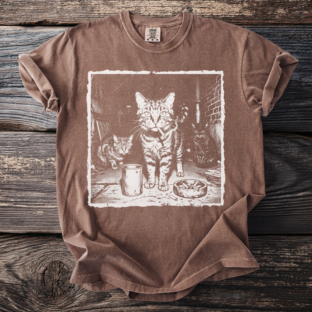 T-shirt featuring a graphic of three cats, one with a cigarette, and an ashtray.